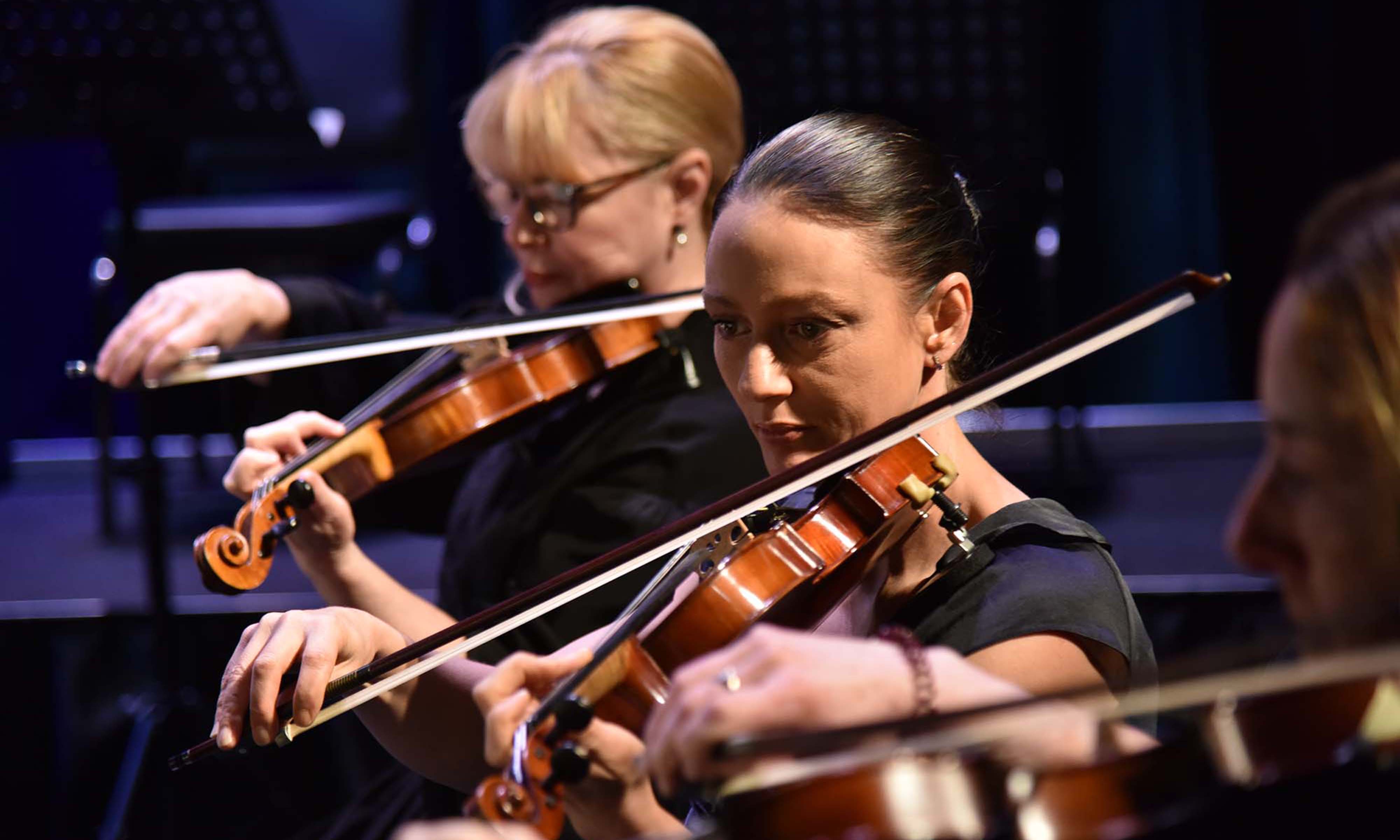 Two violinists perform on stage